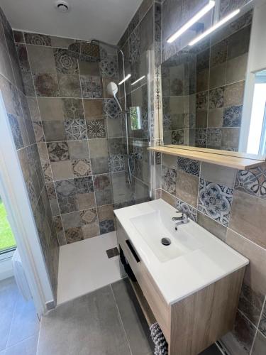 une salle de bain avec un lavabo blanc et une douche dans l'établissement Famille ou entre Amis au Grau d Agde appartements pour 10 Pers, au Grau-dʼAgde