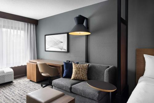 a hotel room with a couch and a desk at Hyatt Place Kansas City/Overland Park/Convention Center in Overland Park
