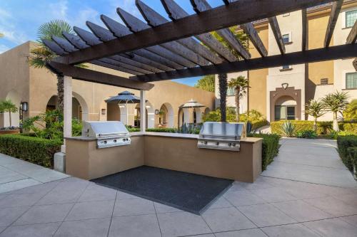 a patio with two bbqs under a pergola at Homewood Suites by Hilton San Diego Airport-Liberty Station in San Diego