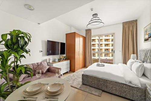 a bedroom with a bed and a living room at FIRST CLASS Studio Cozy & Chic Retreat in Dubai