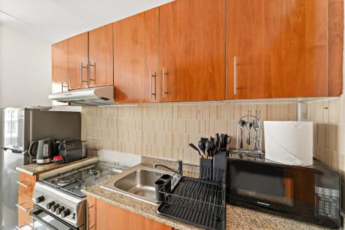 a kitchen with a sink and a microwave at FIRST CLASS Studio Cozy & Chic Retreat in Dubai