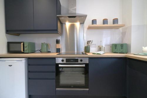 a kitchen with a stove and a counter top at Signature - St James House in Abbotsinch