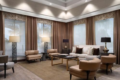 a living room with a couch and a table and chairs at Hampton Inn & Suites Orlando/Downtown South - Medical Center in Orlando