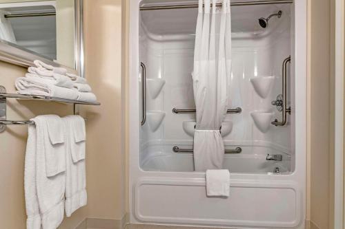 a bathroom with a shower and white towels at Quality Inn & Suites Quispamsis in Saint John