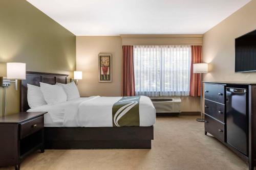 a hotel room with a large bed and a window at Quality Inn & Suites Quispamsis in Saint John
