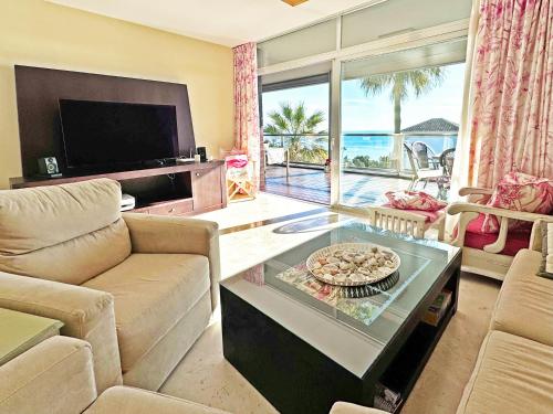 Una sala de estar con un sofá y un televisor. en Topfloor apartment with terrace and sea views, en Sotogrande