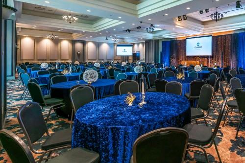a conference room with blue tables and chairs and a screen at Clarion Hotel & Conference Centre in Abbotsford