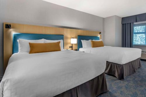 two large white beds in a hotel room at Clarion Hotel & Conference Centre in Abbotsford