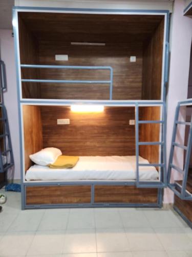 a bunk bed with a book on it in a room at Over True Dorms in Navi Mumbai