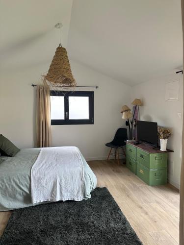 une chambre avec un lit et un bureau avec un ordinateur dans l'établissement La Cabane du Mascaret, à Vayres