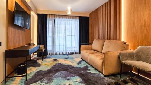 a living room with a couch and a piano at Hotel Bucura in Călimăneşti