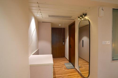 a bathroom with a mirror and a hallway at Hotel Square 36 in Kota