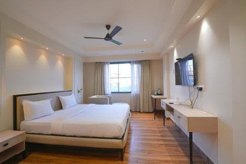 a bedroom with a white bed and a window at Hotel Square 36 in Kota