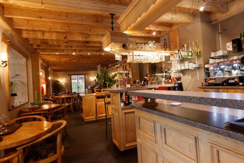 un restaurante con un bar con mesas y sillas en L'Auberge au Bord du Lac en Gérardmer