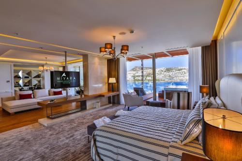 Habitación grande con cama y sala de estar. en Mivara Luxury Bodrum, en Gundogan