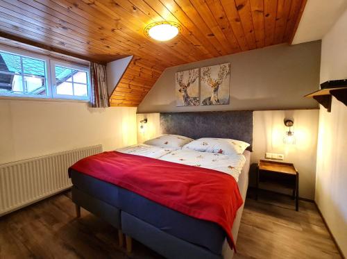 a bedroom with a large bed with a wooden ceiling at Gurkhof Ferienwohnungen in Gnesau