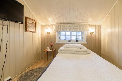 una camera da letto con un grande letto bianco e una finestra di Cozy apartment in the city center a Leknes