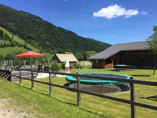 a view of a house with a pool and an umbrella at Gurkhof Ferienwohnungen in Gnesau