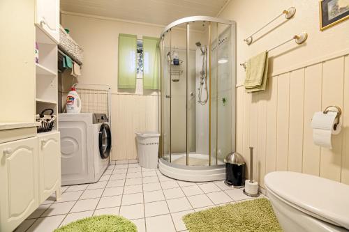un bagno con doccia e lavatrice di Cozy apartment in the city center a Leknes