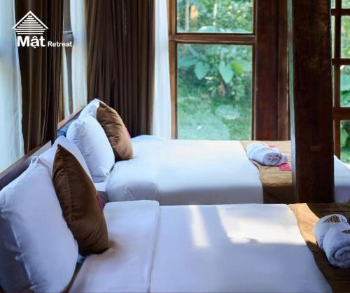 a living room with two beds and a window at Mật Retreat in Ba Vì