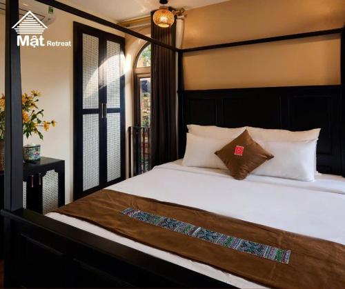 a bedroom with a large bed with white sheets and pillows at Mật Retreat in Ba Vì