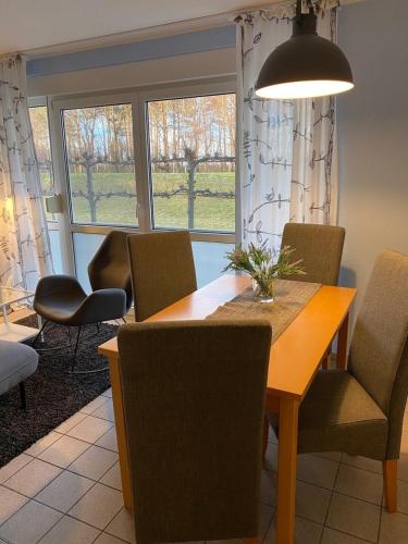 a dining room with a table and chairs and windows at Seestraße 70, Ap 30 in Zingst