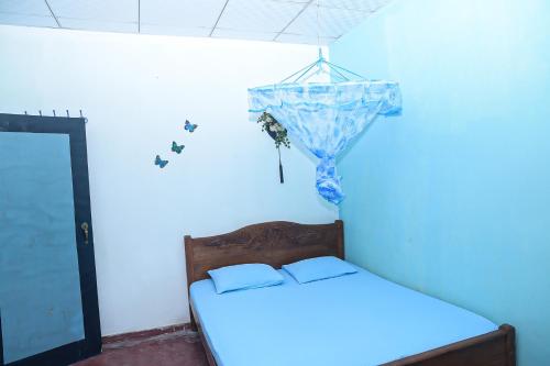 Un dormitorio con una cama y una pared azul. en Firenze, en Ambalangoda