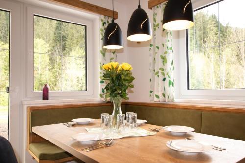 a dining room table with a vase of flowers on it at Ferienwohnung zur Kundler Klamm by FeWo-Plan WILD010 in Dorf