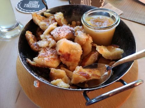 a bowl of fried food with a spoon and a drink at Ferienwohnung zur Kundler Klamm by FeWo-Plan WILD010 in Dorf