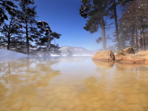 a misty river with rocks in the water at Urabandai Lake Resort Goshiki no Mori in Kitashiobara