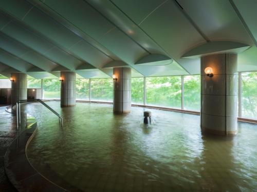 a dog standing in the water in a building at Urabandai Lake Resort Goshiki no Mori in Kitashiobara