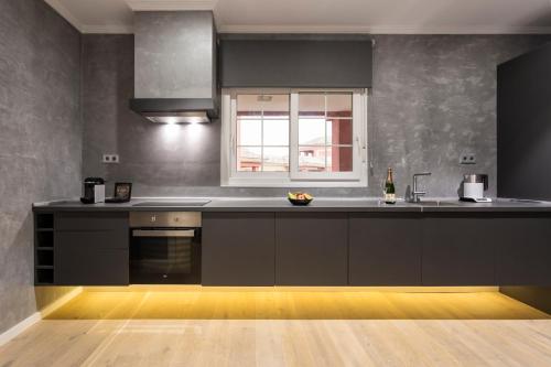 a kitchen with black cabinets and a window at Ama Islantilla Resort in Islantilla