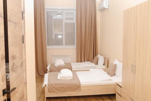 two beds in a room with a window at Belon Garden Hotel in Prigorodnyy