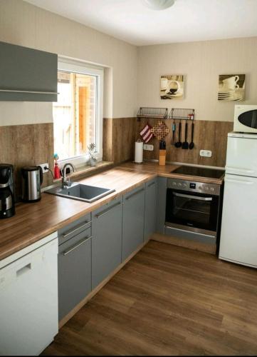 a kitchen with gray cabinets and a sink and a refrigerator at Ferienwohnung Kleine Gasse in Lathen