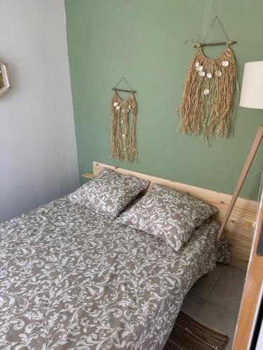 - une chambre avec un lit et des plantes séchées sur le mur dans l'établissement Chez Elena, à La Brillanne