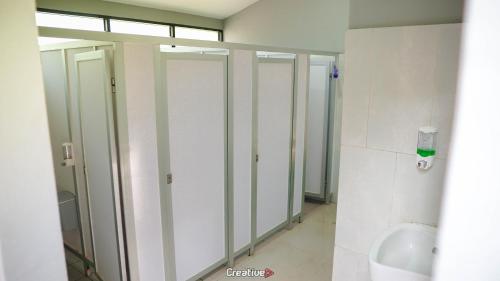 un bagno con quattro bancarelle con lavandino e orinatoio di Jolotundo Glamping and Edupark a Sagi