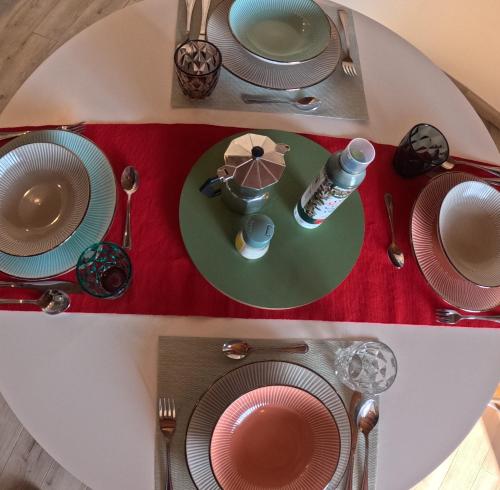 a table with plates and utensils on a table at La Mansarda in Quarto