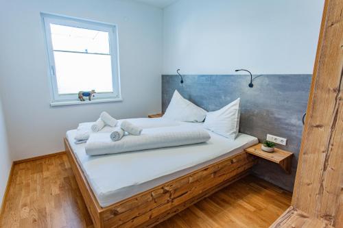 a bedroom with a bed with white sheets and a window at Happy Aich 3 by Alpenidyll Apartments in Aich