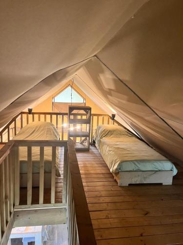 a bedroom with two beds in a tent at Glampingtent de Saskerlei, de Woudhaven in De Woude