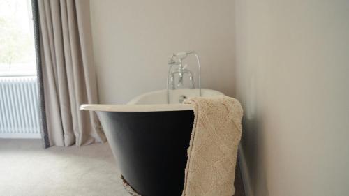 a bath tub with a faucet and a towel at Bridge View Cottage in Cawood