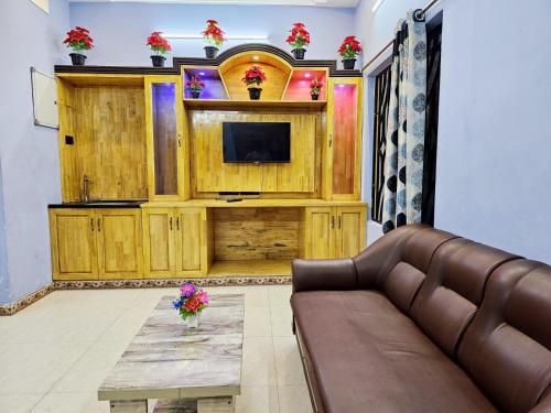 a living room with a couch and a tv at Seaside Escape Villa With Swimming Pool in Puducherry