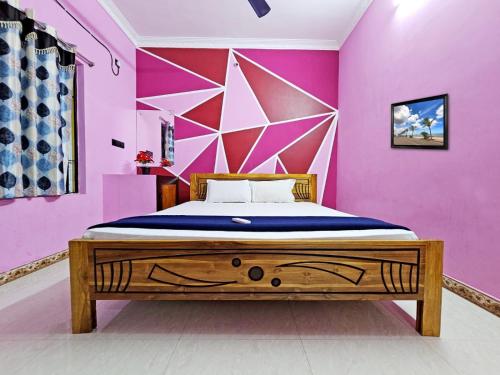 a bedroom with a bed with a pink wall at Seaside Escape Villa With Swimming Pool in Puducherry