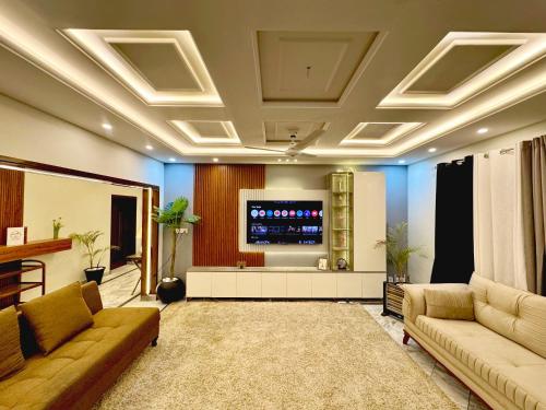 a living room with couches and a flat screen tv at Luxury kanal portion in Islamabad in Islamabad