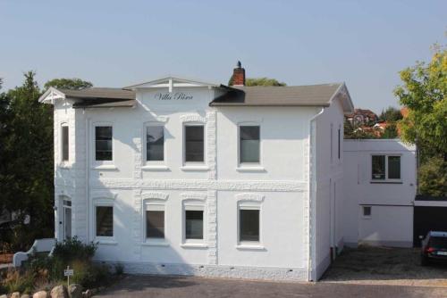 Un edificio blanco con un cartel en él. en Ferienhaus Ostseeliebe, en Dahme