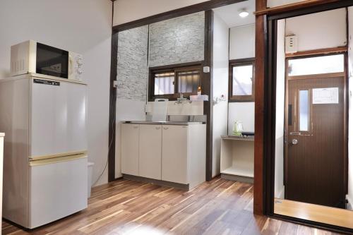 a kitchen with a refrigerator and a sink at TSUBAME 103 staying private home in Osaka
