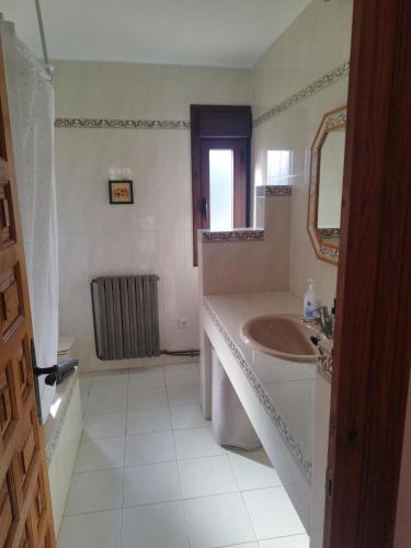 a white bathroom with a sink and a mirror at Casa Marco in Gistaín