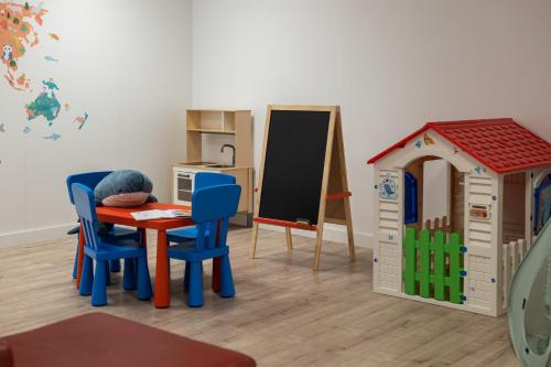 a room with a table and chairs and a chalkboard at Naitly Barcelona Poblenou in Barcelona