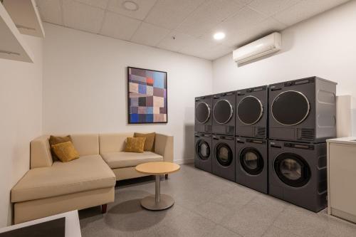 a living room with a couch and washing machines at Naitly Barcelona Poblenou in Barcelona
