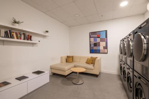 a room with a couch and a table and a refrigerator at Naitly Barcelona Poblenou in Barcelona