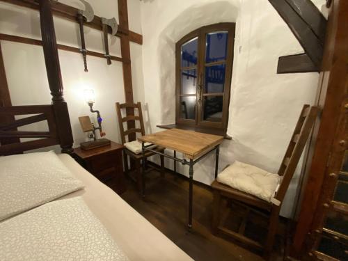 a bedroom with a bed and a table and a chair at Ferienhaus WAFFENKAMMER für 7 Erw im Rittergut Leppersdorf bei Radeberg in Wachau